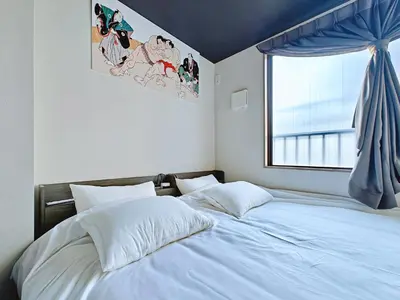 a bedroom with a large white bed with a window at Hamanoya Main in Tokyo