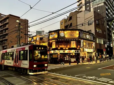 a tram on a city street with buildings at Yama Hotel Otsuka in Tokyo
