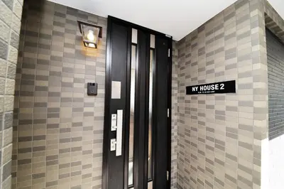 a door in a building with a sign on it at NY House 2\u65b0\u5bbf\u4e09\u968e\u5efa\u30663\u5ba42\u30b7\u30e3\u30ef\u30fc2\u30c8\u30a4\u30ec in Tokyo