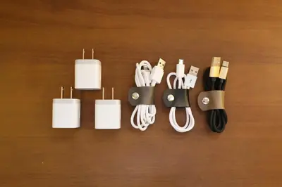 a group of cords and chargers on a wooden table at Shitamachi Skyroom in Yotsugi Private Room in Tokyo