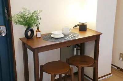 a small table with two chairs and a table with two cups and a plate at Shitamachi Skyroom in Yotsugi Private Room in Tokyo