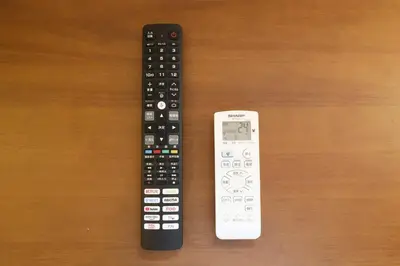 two remote controls sitting next to each other on a table at Shitamachi Skyroom in Yotsugi Private Room in Tokyo