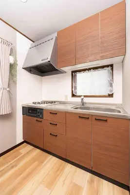 a kitchen with wooden cabinets and a stainless steel sink at Tanuki Apartment Shinjuku West in Tokyo