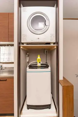 a microwave and a toaster oven on a shelf in a kitchen at Tanuki Apartment Shinjuku West in Tokyo