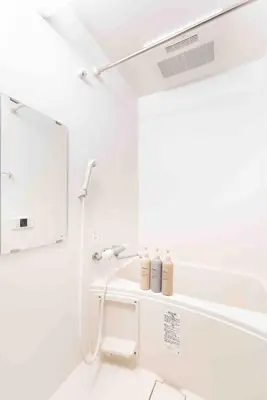 a white bathroom with a shower and a sink at Tanuki Apartment Shinjuku West in Tokyo