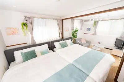a bedroom with a large bed and a couch at Tanuki Apartment Shinjuku West in Tokyo