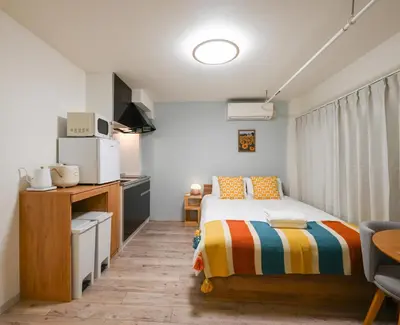 a small bedroom with a bed and a kitchen at Home Story in Tokyo Uguisudani\u30e9\u30a4\u30ba\u65e5\u66ae\u91cc \u6771\u4eac\u5c4b\u8a9e in Tokyo