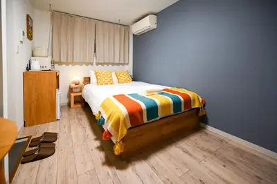 a bedroom with a bed and a blue wall at Home Story in Tokyo Uguisudani\u30e9\u30a4\u30ba\u65e5\u66ae\u91cc \u6771\u4eac\u5c4b\u8a9e in Tokyo