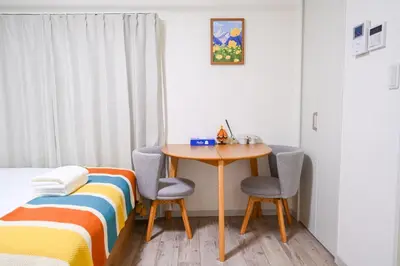 a bedroom with a table and two chairs and a bed at Home Story in Tokyo Uguisudani\u30e9\u30a4\u30ba\u65e5\u66ae\u91cc \u6771\u4eac\u5c4b\u8a9e in Tokyo