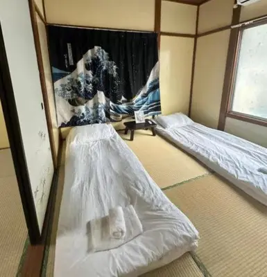a room with two beds and a window at \u6d45\u8349 \u30b9\u30ab\u30a4\u30c4\u30ea\u30fc\u570f10\u5206 \u4ea4\u901a\u81f3\u4fbf \u6d45\u8349\u5bfa\u89b3\u5149 \u53cc\u9b5a\u306e\u5bbf \u6771\u5411\u5cf61 in Tokyo