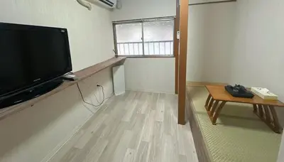 a living room with a flat screen tv and a table at \u6d45\u8349 \u30b9\u30ab\u30a4\u30c4\u30ea\u30fc\u570f10\u5206 \u4ea4\u901a\u81f3\u4fbf \u6d45\u8349\u5bfa\u89b3\u5149 \u53cc\u9b5a\u306e\u5bbf \u6771\u5411\u5cf61 in Tokyo