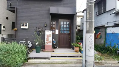 a house with a brown door and some plants at Dreamy Music Cafe Bar in Tokyo
