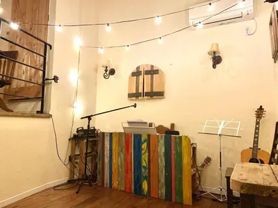 a room with a stage with a microphone and guitars at Dreamy Music Cafe Bar in Tokyo