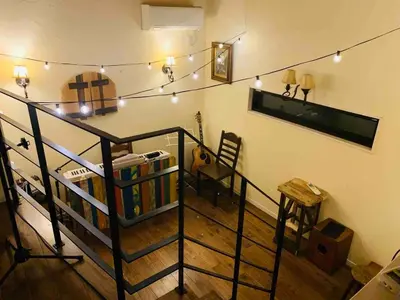 a room with a staircase with a book shelf and lights at Dreamy Music Cafe Bar in Tokyo