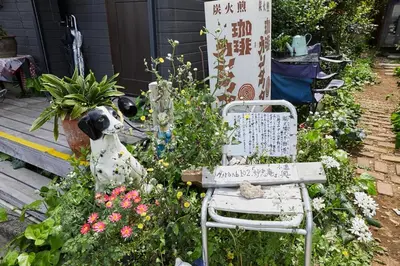 a garden with a dog sitting next to a chair at Dreamy Music Cafe Bar in Tokyo