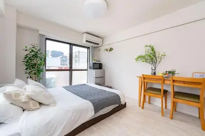 a bedroom with a bed and a desk and a window at Oji Inn \u738b\u5b50\u30a4\u30f3 in Tokyo