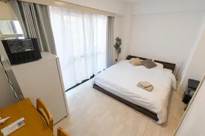 a bedroom with a bed with a laptop on it at Oji Inn \u738b\u5b50\u30a4\u30f3 in Tokyo