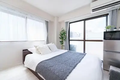 a bedroom with a bed and a large window at Oji Inn \u738b\u5b50\u30a4\u30f3 in Tokyo
