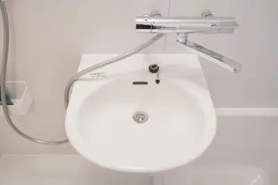 a white bathroom sink with a blow dryer above it at Mari Hotel in Tokyo