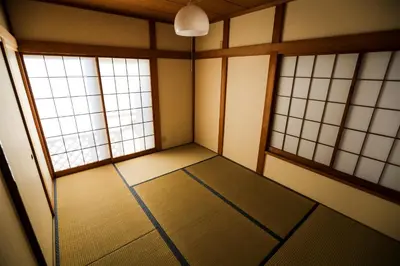 an empty room with three windows in a room at J's Backpackers in Tokyo