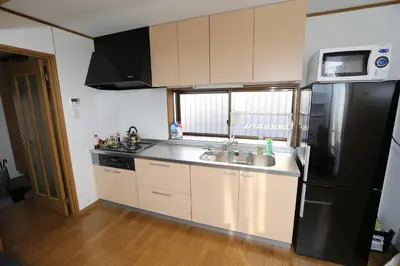 a kitchen with a black refrigerator and a sink at J's Backpackers in Tokyo