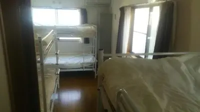 a room with two bunk beds and a window at J's Backpackers in Tokyo