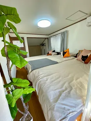 a bedroom with two beds and a plant at AiES \u5317\u5343\u4f4f \u5317\u5343\u4f4f\u7ad9\u8d708\u5206 \u76f4\u8fbe\u6674\u7a7a\u5854Asakusa\u79cb\u53f6\u539f\u4e0a\u91ce\u4e1c\u4eac\u94f6\u5ea7\u516d\u672c\u6728\u6d89\u8c37 \u6700\u592713\u4eba 100\u5e73\u65b9\u6237\u5efa5\u5ba49\u5e8a in Tokyo