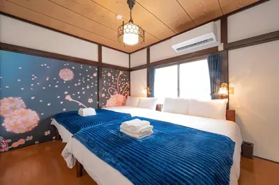 a bedroom with a bed with a blue blanket at SAKURA villa \uff21166 in Tokyo