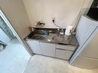 a small kitchen with a sink and a refrigerator at \u6d45\u8349\u6c11\u6cca301 in Tokyo