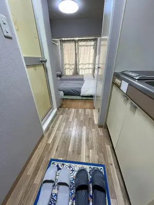 a room with a mat on the floor with a bed at \u6d45\u8349\u6c11\u6cca303 in Tokyo