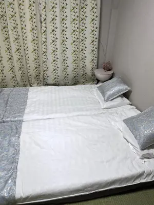 a bed with white sheets and pillows in a bedroom at \u6d45\u8349\u6c11\u6cca303 in Tokyo