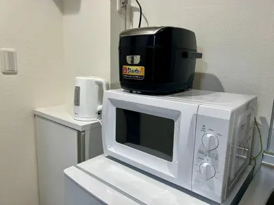 a coffee maker on top of a microwave at Apartment Hotel in Katsushika City in Tokyo