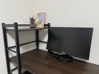 a computer monitor sitting on a desk next to a wall at Apartment Hotel in Katsushika City in Tokyo