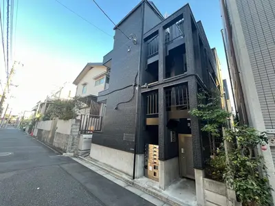 a black building on the side of a street at Apartment Hotel in Katsushika City in Tokyo