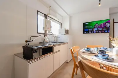 a kitchen with a sink and a table with chairs at HouseHotel\u4e94\u53cd\u7530 in Tokyo