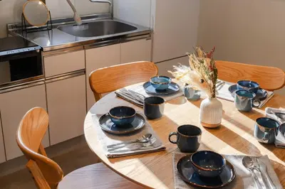 a kitchen with a table with plates and utensils at HouseHotel\u4e94\u53cd\u7530 in Tokyo