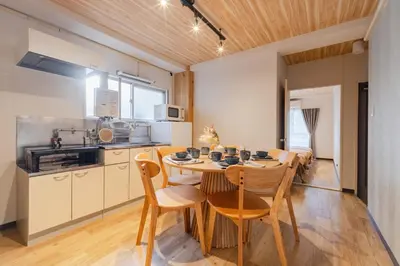 a kitchen and dining room with a wooden table and chairs at HouseHotel\u4e94\u53cd\u7530 in Tokyo