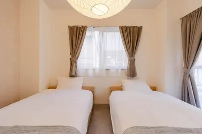 two beds in a room with a window at HouseHotel\u4e94\u53cd\u7530 in Tokyo