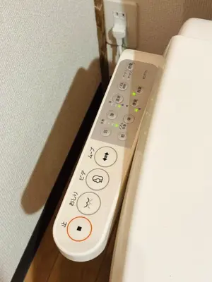 a remote control sitting on the side of a bed at Retro Showa Home 9min from station Direct to Narita Near Disney Bus 48mim in Tokyo