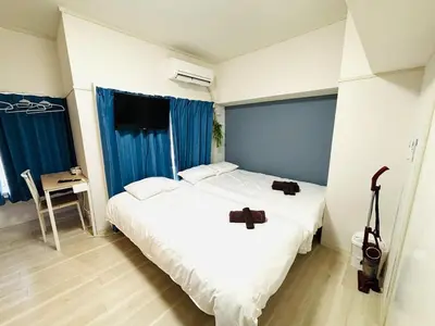 a bedroom with two beds and a television in it at 1min from station Hokusai and 2F nice view 2DK 30min from Tokyo station convenience store 30sec onsen 10min Haneda 55min in Tokyo