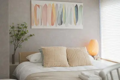 a bedroom with a bed with pillows and a painting at Good access to Shinjuku! Japandi Style Room in Nakano, Tokyo - Podhouse Nakano in Tokyo