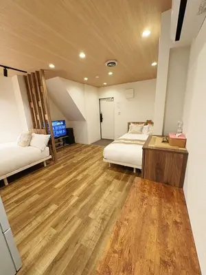 a bedroom with two beds and a wooden floor at Private Room near Iriya in Tokyo