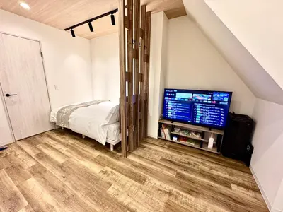 a bedroom with a bed and a flat screen tv at Private Room near Iriya in Tokyo