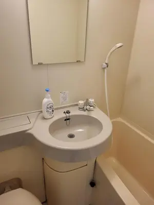 a bathroom with a white sink and a mirror at 2 Units in 1 Listing near Nakano CBD and Broadway in Tokyo