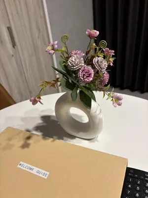 a white vase filled with purple flowers on a table at Opening SALE! Stylish Room in Meguro Near Shibuya! in Tokyo