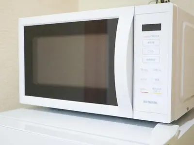 a white microwave oven sitting on top of a shelf at MSTAY\u6771\u5411\u5cf6one in Tokyo