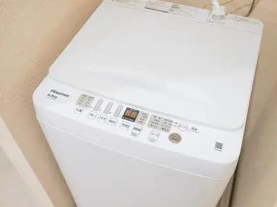 a white washing machine sitting next to a wall at MSTAY\u6771\u5411\u5cf6one in Tokyo