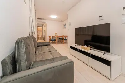 a living room with a couch and a flat screen tv at Newly Built 4-Bedroom House in Shopping Street, 8-Min Walk from Akabane Station in Tokyo