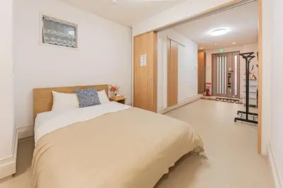 a bedroom with a large bed and a staircase at Newly Built 4-Bedroom House in Shopping Street, 8-Min Walk from Akabane Station in Tokyo