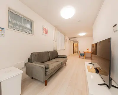 a living room with a couch and a flat screen tv at Newly Built 4-Bedroom House in Shopping Street, 8-Min Walk from Akabane Station in Tokyo